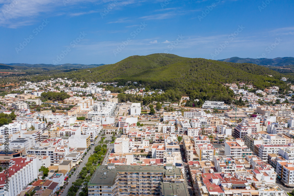 Aerial photo of the beautiful island of Ibiza in Spain showing the town centre and hotels on a bright sunny summers day with the mountains in the background