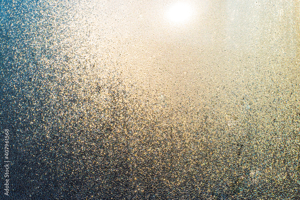Misted window with drops of moisture that glows in the sun