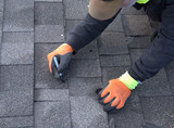 Professional roofer uses a marking pen to color the nail heads black so they will blend with the shingles.