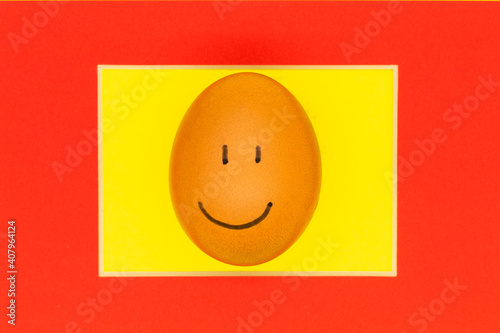 an Easter egg with a smile in a red frame. The concept of Easter