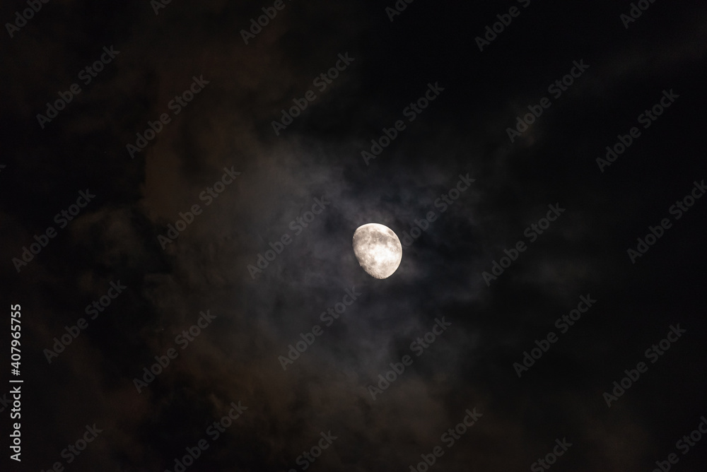 The moon among the stars and clouds