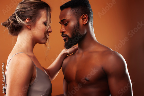 Young pretty couple diverse races together posing sensitive on brown background  lifestyle people concept
