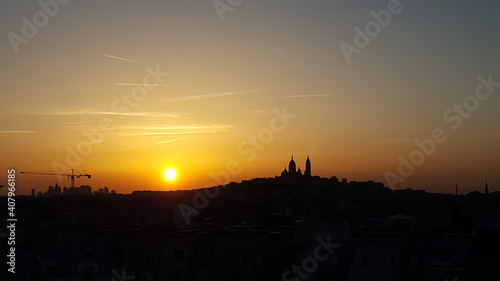 Relaxing sunset on a clear day in Paris. The colors of the sky shine in purple, red and orange. The silhouette of the church Sacre Coeur in Montmartre is in the background.  © Alice Photography