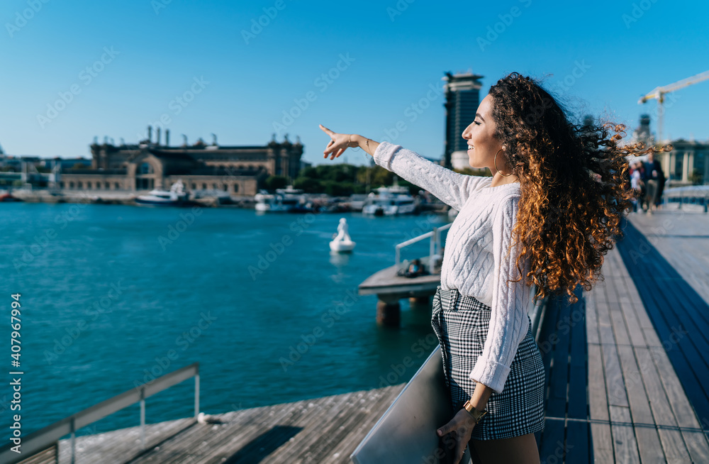 Happy ethnic woman standing near sea