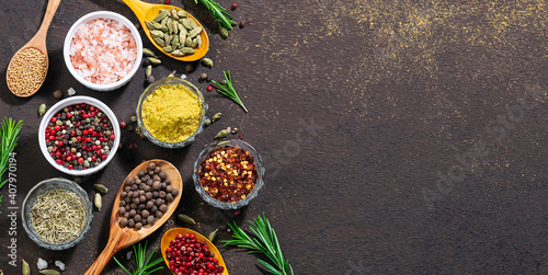 Fototapeta Naklejka Na Ścianę i Meble -  Assortment of natural organic aromatic spices and herbs on dark stone rustic background. Spices market banner template. Food blog cover mock up. Copy space for your design.