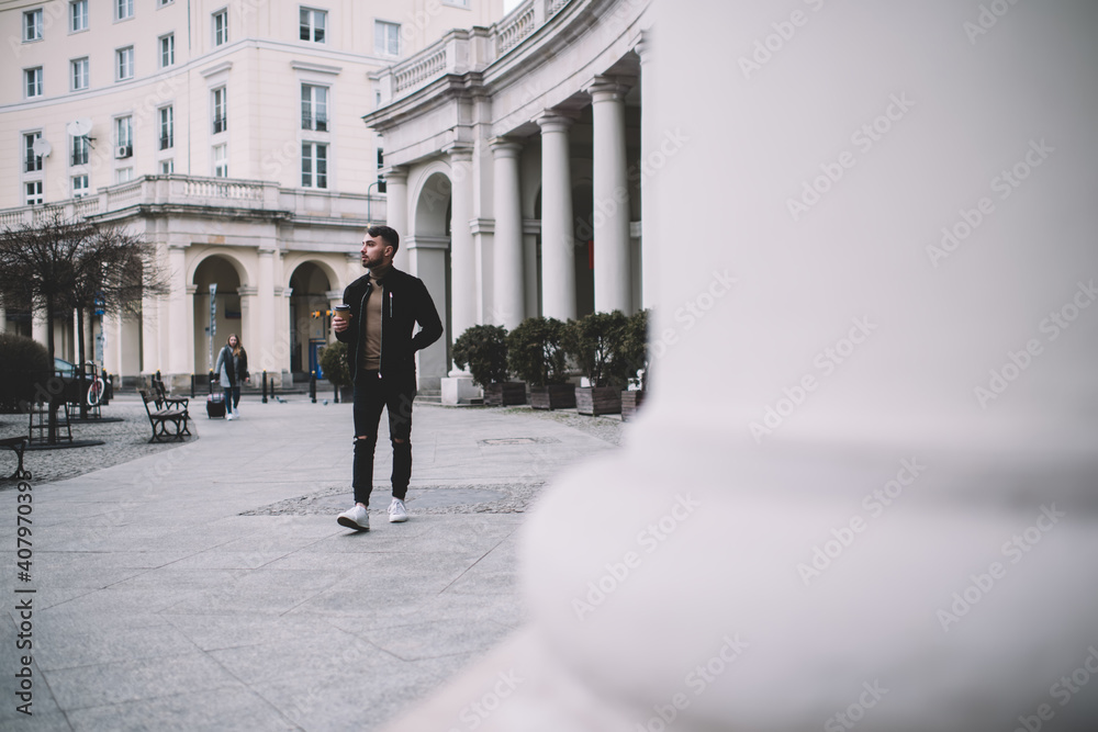 Man walking on street with takeaway coffee