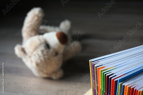 multicolored school notebooks. homework. on the floor lies a teddy bear toy. hard time