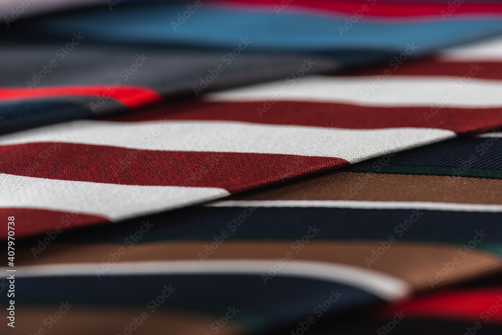 close-up view, many colorful folded ties, sloping horizon. Textured background of classic fabrics close-up view, many colorful folded ties, sloping horizon. Textured background of classic fabrics