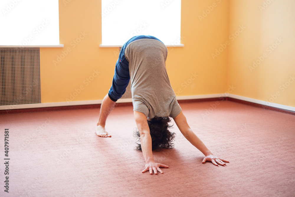 Young caucasian male doing yoga in a yoga studio.