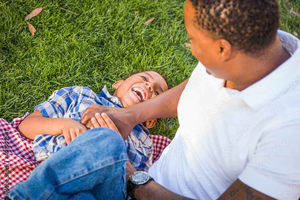 Happy African American Father and Mixed Race Son Playing At The Park Happy African American Father and Mixed Race Son Playing At The Park