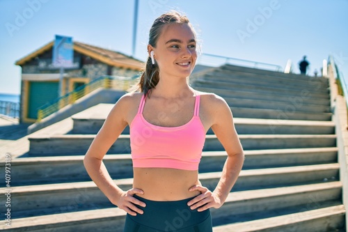 Young blonde sportswoman using earphones doing exercise at the city © Krakenimages.com