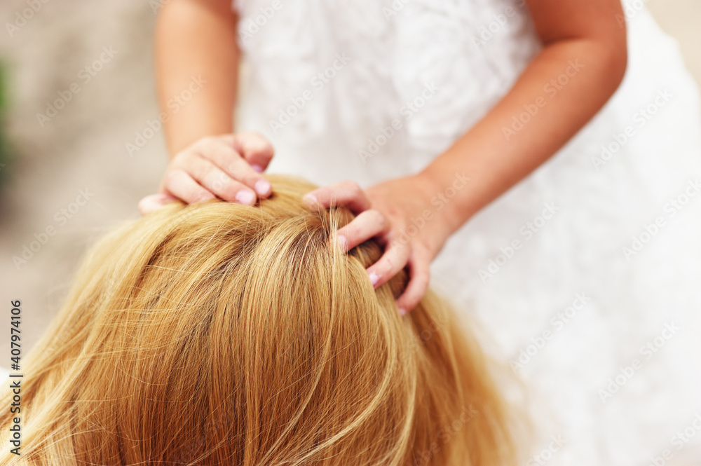 Obraz premium Young blonde mother in dress playing with little kid blonde daughter in the park.