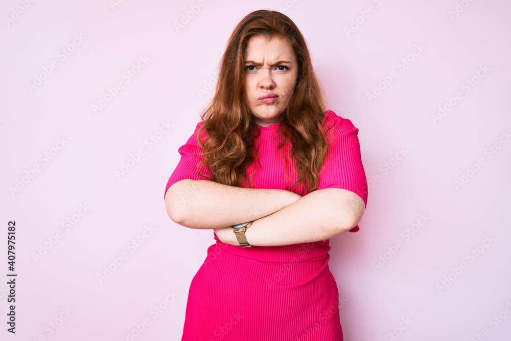 Young redhead woman wearing casual clothes skeptic and nervous, disapproving expression on face with crossed arms. negative person. Young redhead woman wearing casual clothes skeptic and nervous, disapproving expression on face with crossed arms. negative person.