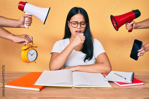 Young beautiful asian girl stuying for university getting stressed out feeling unwell and coughing as symptom for cold or bronchitis. health care concept. photo