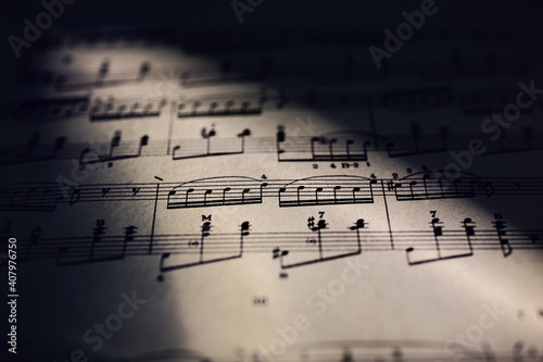 Close-up of music sheet in candle fire lights.