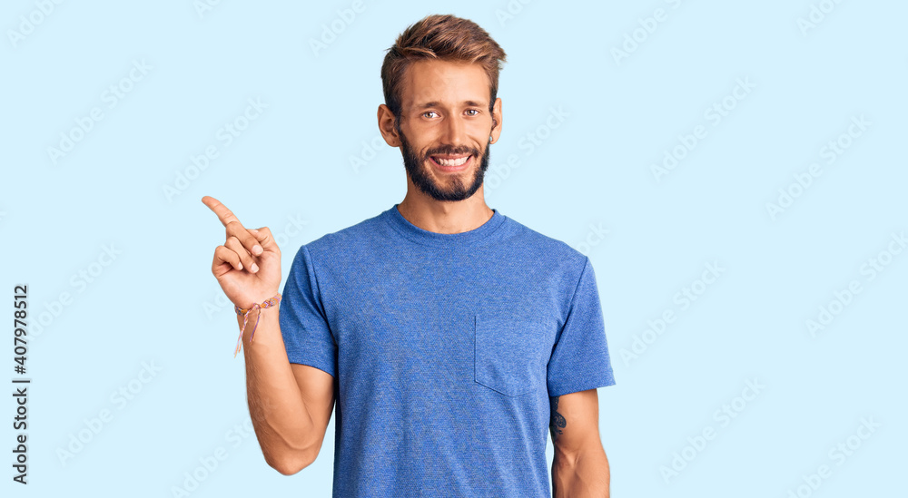 Handsome blond man with beard wearing casual clothes smiling happy pointing with hand and finger to the side Handsome blond man with beard wearing casual clothes smiling happy pointing with hand and finger to the side