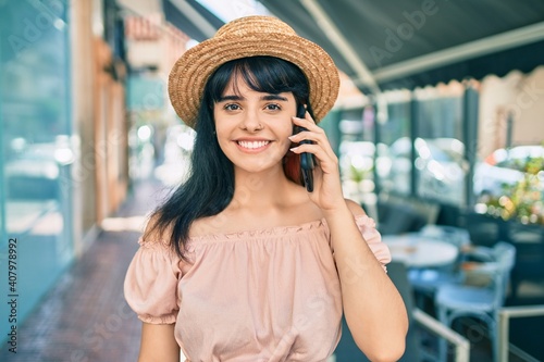 Young hispanic tourist girl wearing summer style talking on the smartphone at the city. © Krakenimages.com