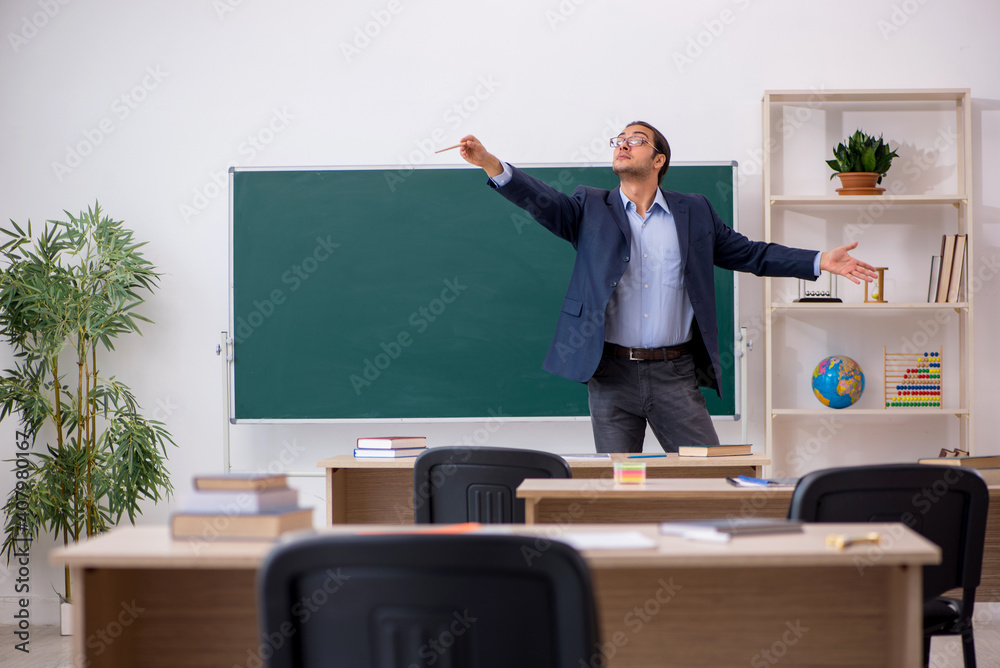 Young male teacher in front of green board Young male teacher in front of green board