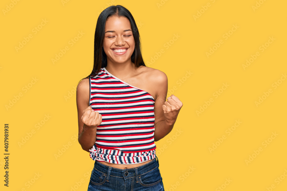 Beautiful hispanic woman wearing casual clothes excited for success with arms raised and eyes closed celebrating victory smiling. winner concept. Beautiful hispanic woman wearing casual clothes excited for success with arms raised and eyes closed celebrating victory smiling. winner concept.