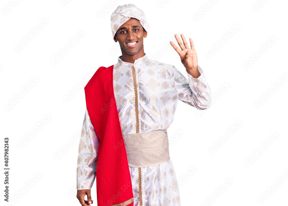African handsome man wearing tradition sherwani saree clothes showing and pointing up with fingers number four while smiling confident and happy. African handsome man wearing tradition sherwani saree clothes showing and pointing up with fingers number four while smiling confident and happy.