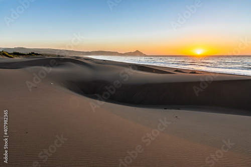 An amazing sea view during sunset time of an awe sandy beach full of sand dunes till the infinite. Idyllic natural landscape for going back to nature and enjoy the outdoors again