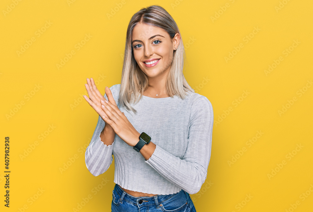 Beautiful blonde woman wearing casual clothes clapping and applauding happy and joyful, smiling proud hands together Beautiful blonde woman wearing casual clothes clapping and applauding happy and joyful, smiling proud hands together