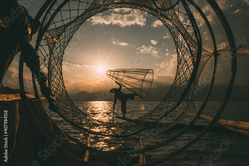 夕暮れの湖と漁師
