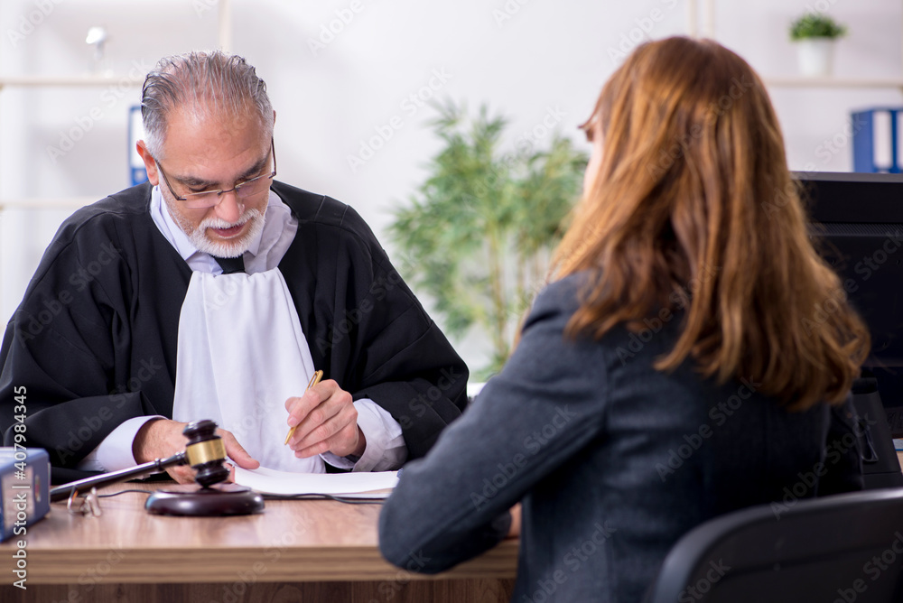 Old male judge and female client in the office Old male judge and female client in the office