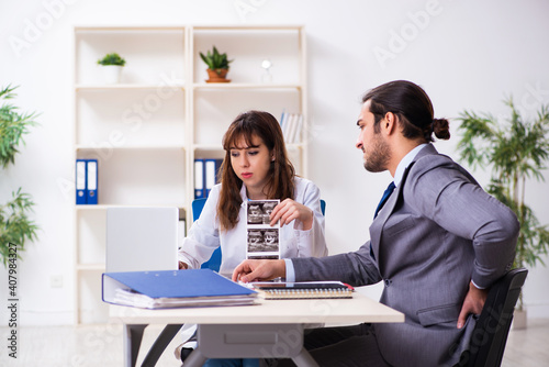 Young female doctor and sick businessman in the office © Elnur