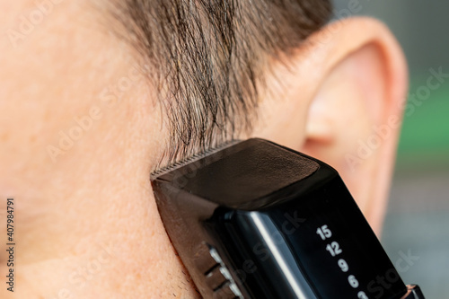 Quadro em tela Clipper trimming hair. Trimming short Sideburns. Close-up