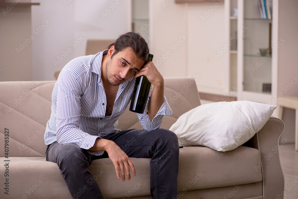 Young drunk man suffering at home