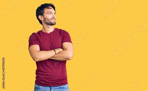 Handsome hispanic man wearing casual clothes looking to the side with arms crossed convinced and confident