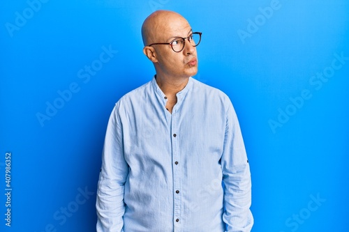 Middle age bald man wearing casual clothes and glasses smiling looking to the side and staring away thinking. © Krakenimages.com