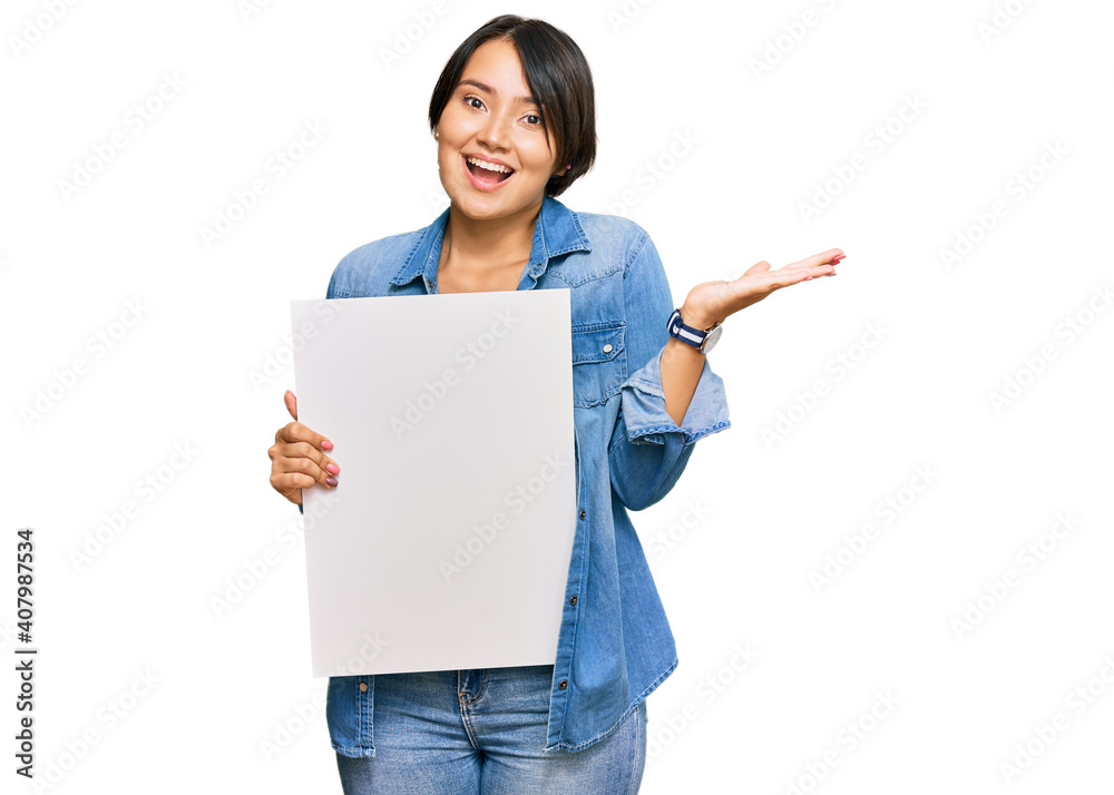 Beautiful young woman with short hair holding blank empty banner celebrating victory with happy smile and winner expression with raised hands Beautiful young woman with short hair holding blank empty banner celebrating victory with happy smile and winner expression with raised hands