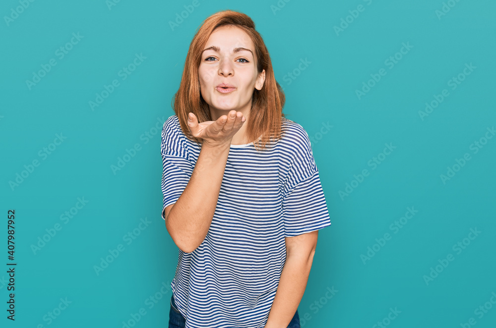 Young caucasian woman wearing casual clothes looking at the camera blowing a kiss with hand on air being lovely and sexy. love expression.