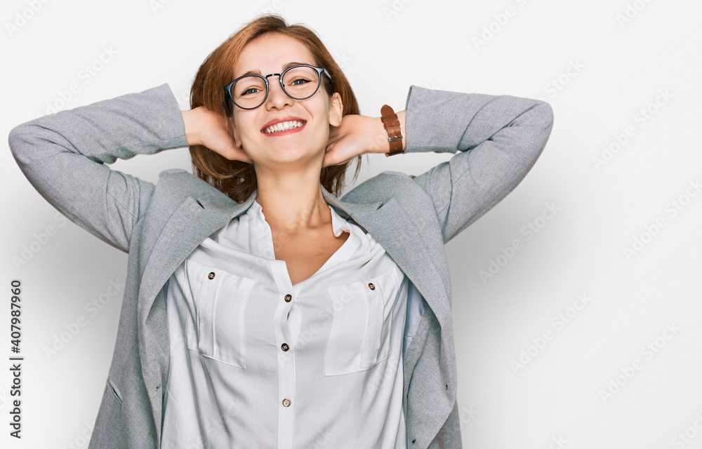 Young caucasian woman wearing business style and glasses relaxing and stretching, arms and hands behind head and neck smiling happy Young caucasian woman wearing business style and glasses relaxing and stretching, arms and hands behind head and neck smiling happy