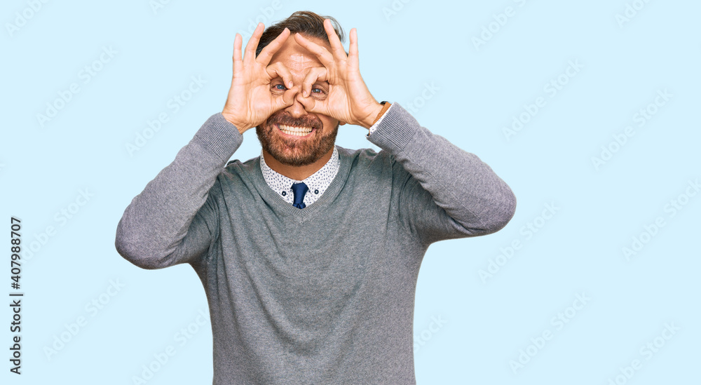 Handsome middle age man wearing business clothes doing ok gesture like binoculars sticking tongue out, eyes looking through fingers. crazy expression. Handsome middle age man wearing business clothes doing ok gesture like binoculars sticking tongue out, eyes looking through fingers. crazy expression.