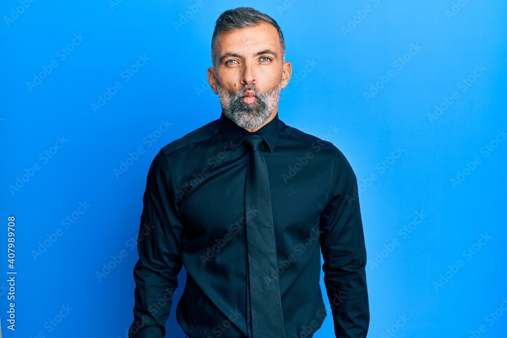 Middle age handsome man wearing business shirt and tie making fish face with lips, crazy and comical gesture. funny expression. Middle age handsome man wearing business shirt and tie making fish face with lips, crazy and comical gesture. funny expression.