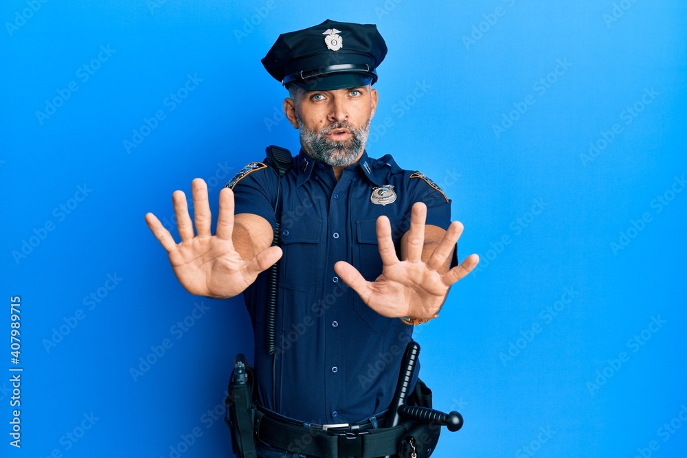 Middle age handsome man wearing police uniform doing stop gesture with hands palms, angry and frustration expression Middle age handsome man wearing police uniform doing stop gesture with hands palms, angry and frustration expression