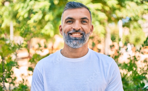 Middle age grey-haired man smiling happy standing at the park.