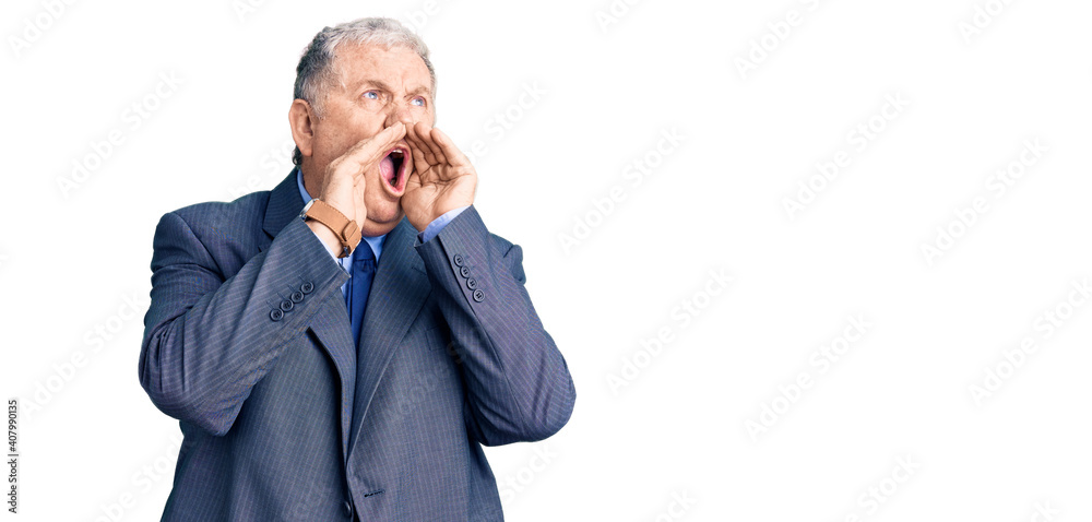 Senior grey-haired man wearing business jacket shouting angry out loud with hands over mouth Senior grey-haired man wearing business jacket shouting angry out loud with hands over mouth