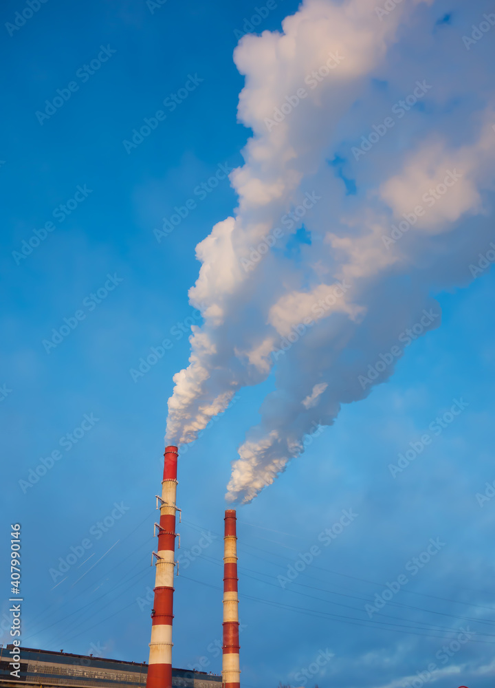factory chimneys emit thick smoke against the blue sky. environmental pollution and ecology concept.
