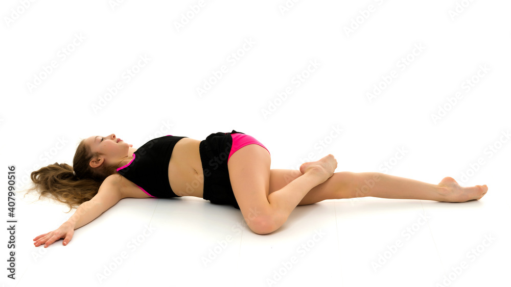 Charming little girl doing gymnastic exercises in the studio on a white background