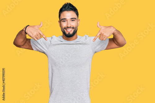 Young man with beard wearing casual grey tshirt looking confident with smile on face, pointing oneself with fingers proud and happy. photo