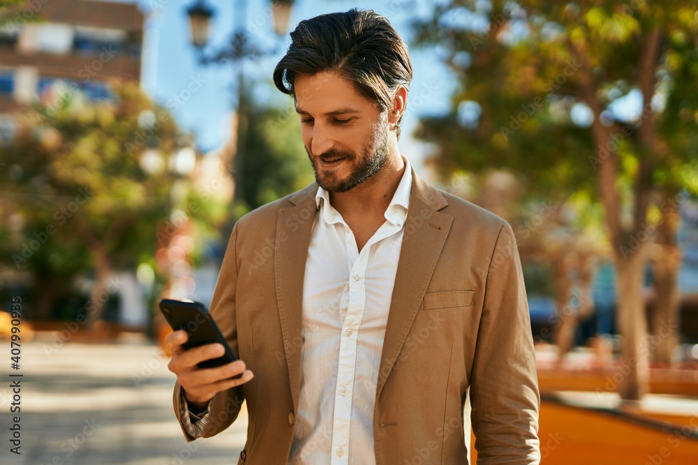 Young hispanic businessman smiling happy using smartphone at the city. Young hispanic businessman smiling happy using smartphone at the city.