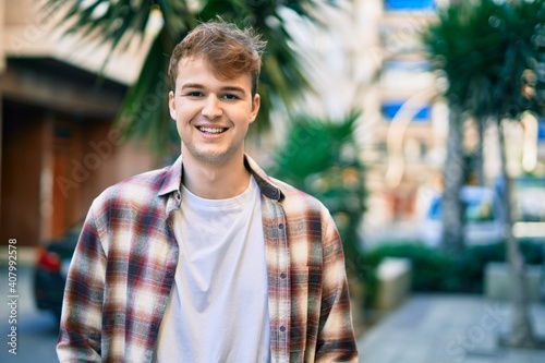 Young caucasian man smiling happy standing at the city.