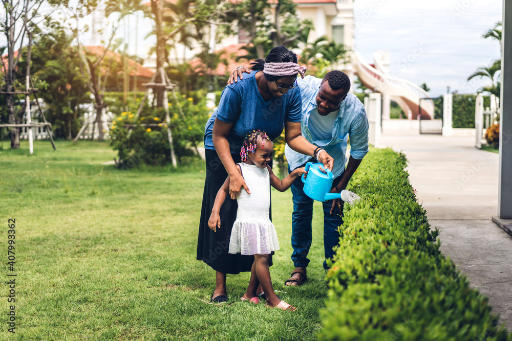 Fototapeta premium Portrait of enjoy happy love black family african american father and mother with little african girl child smiling and play having fun moments good time in summer park at home