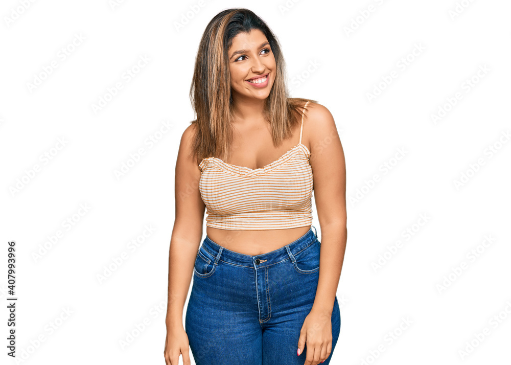 Fototapeta premium Beautiful brunette woman wearing casual clothes looking away to side with smile on face, natural expression. laughing confident.