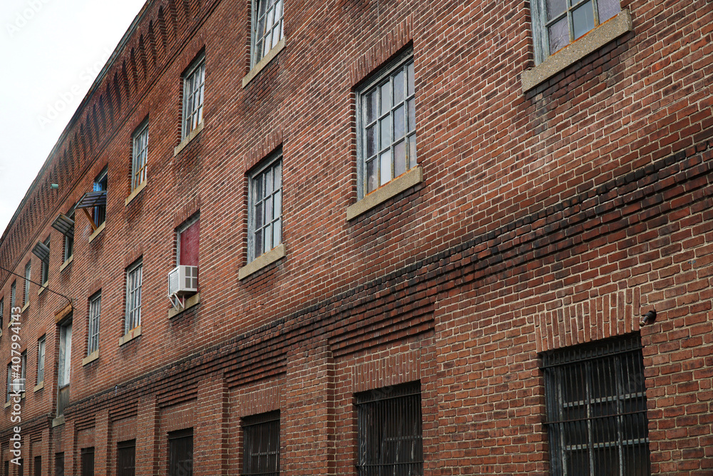 perspective view of old brick wall and window of old factory building