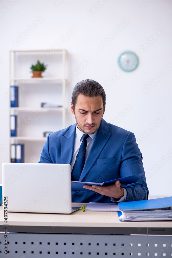 Young male employee working at workplace Young male employee working at workplace